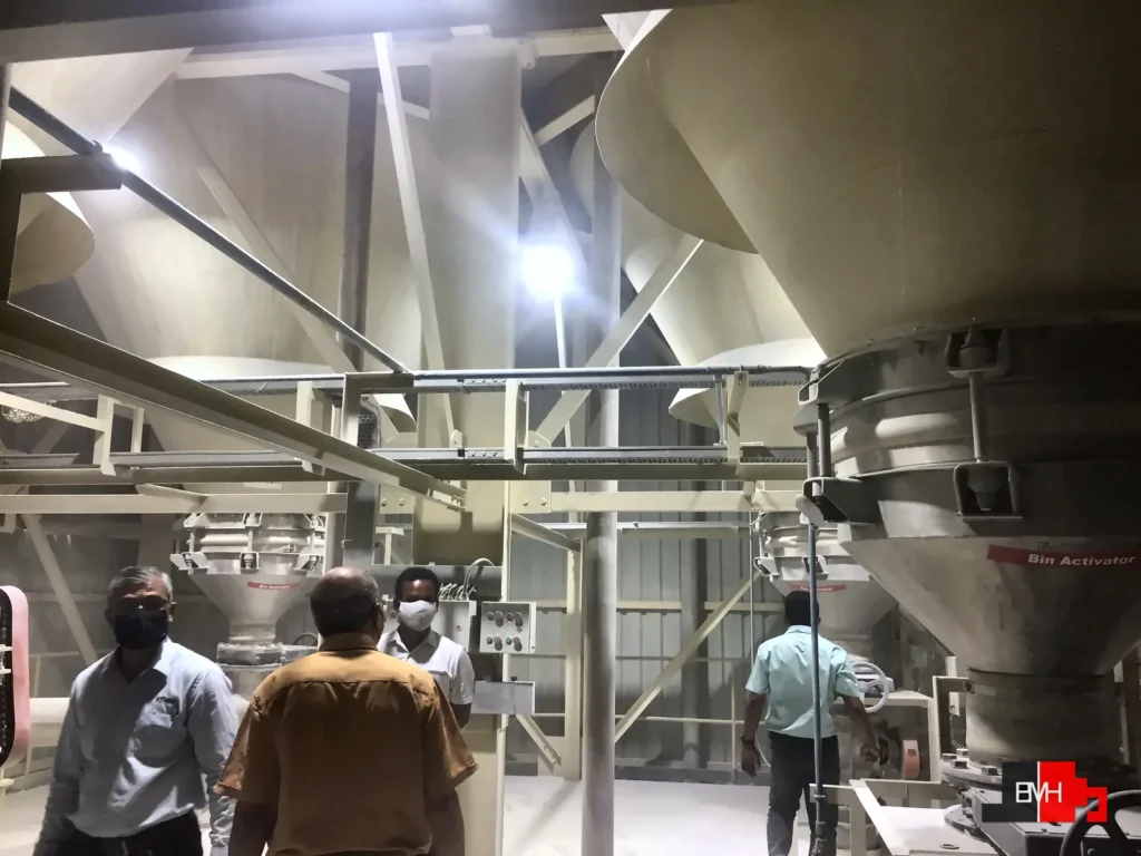 Scorpio mineral batching plant: silo cones with bin activators above weigh hoppers for limestone, talc and china clay